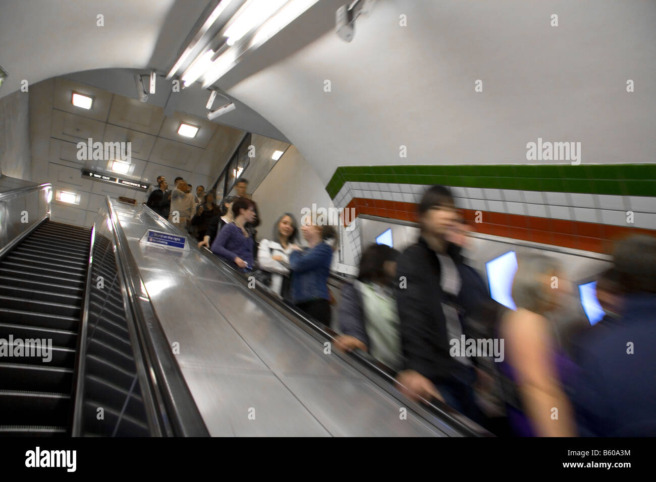 La gente ride un escalator nella metropolitana di Londra metropolitana di Londra Inghilterra Foto Stock