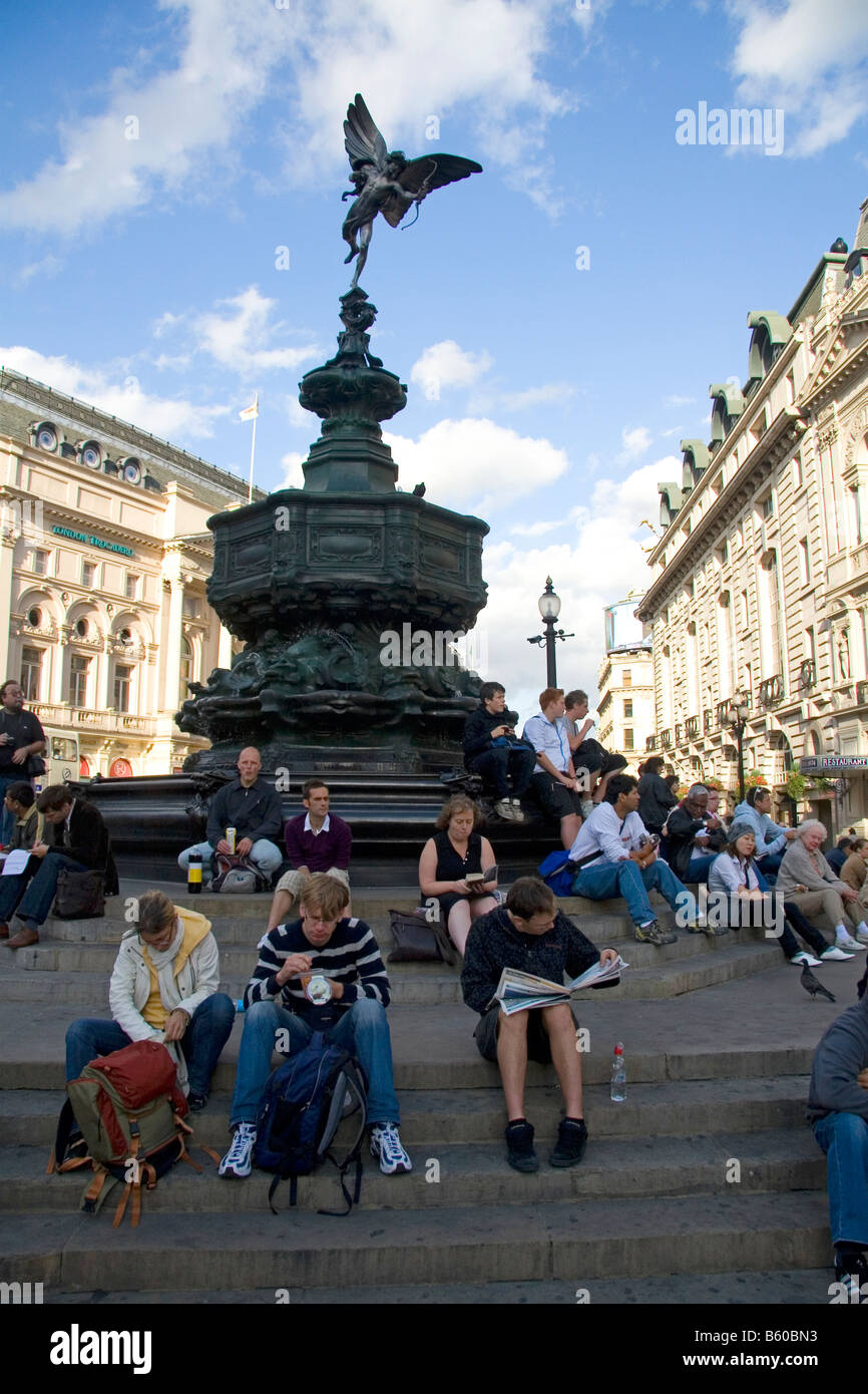 Persone sedersi sui gradini di Shaftesbury Memorial Fontana di Piccadilly Circus London Inghilterra England Foto Stock