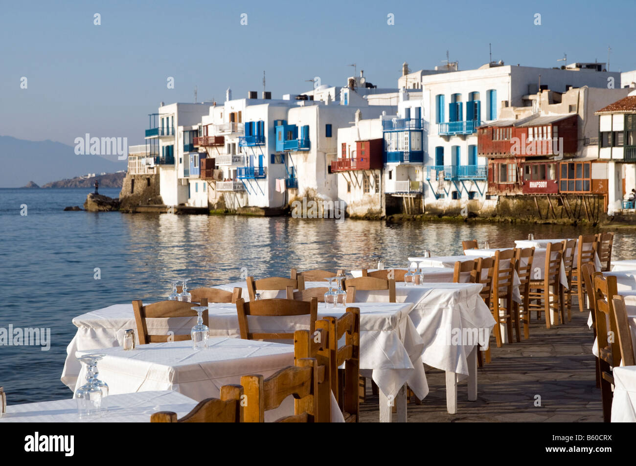 Tabelle vuote al Waterfront Restaurant nella piccola area di Venezia di Mykonos, Grecia Foto Stock