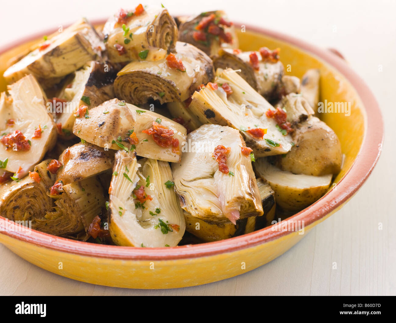 Baby marinato Insalata di carciofi con pomodori secchi Foto Stock