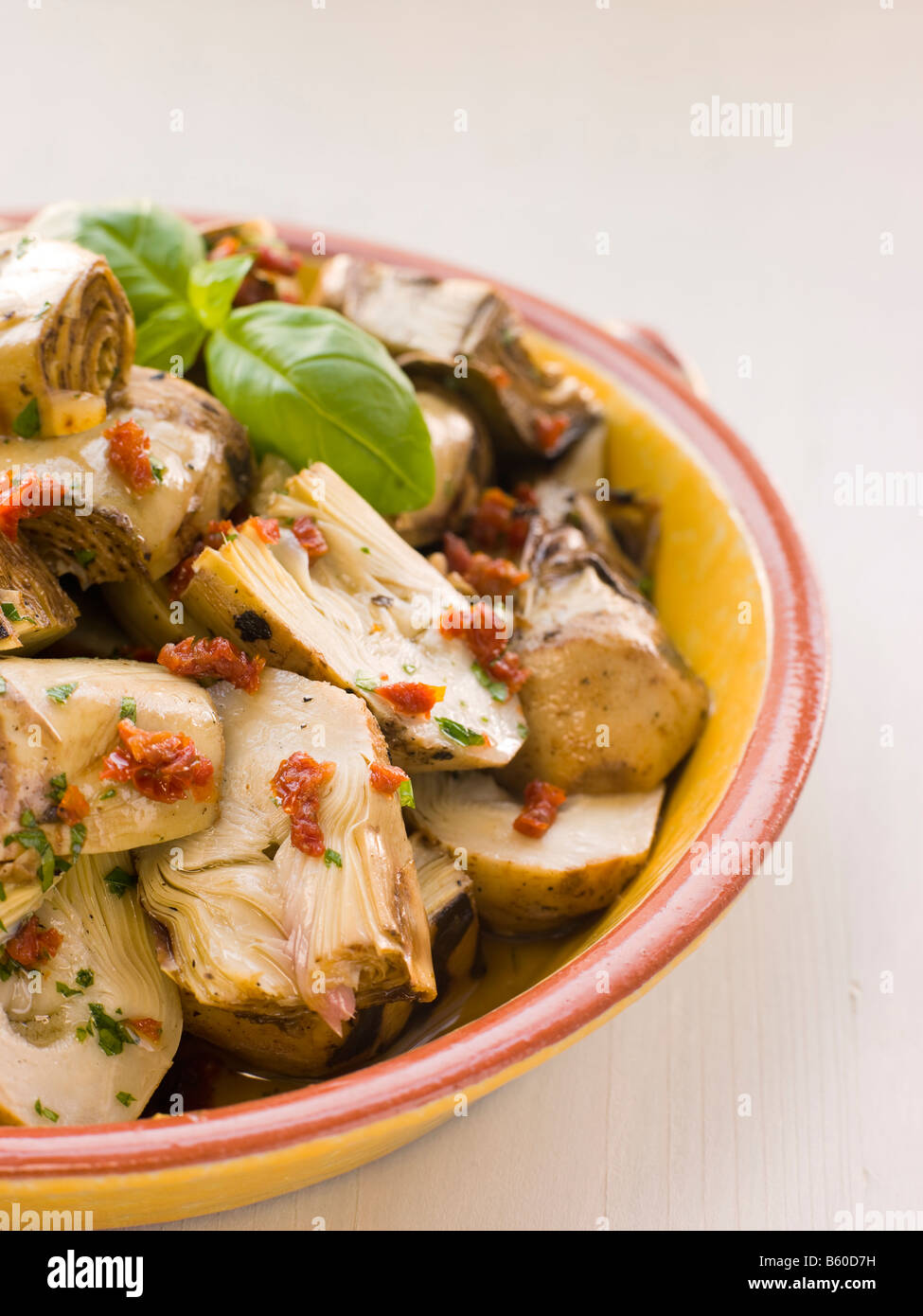 Baby marinato Insalata di carciofi con pomodori secchi Foto Stock