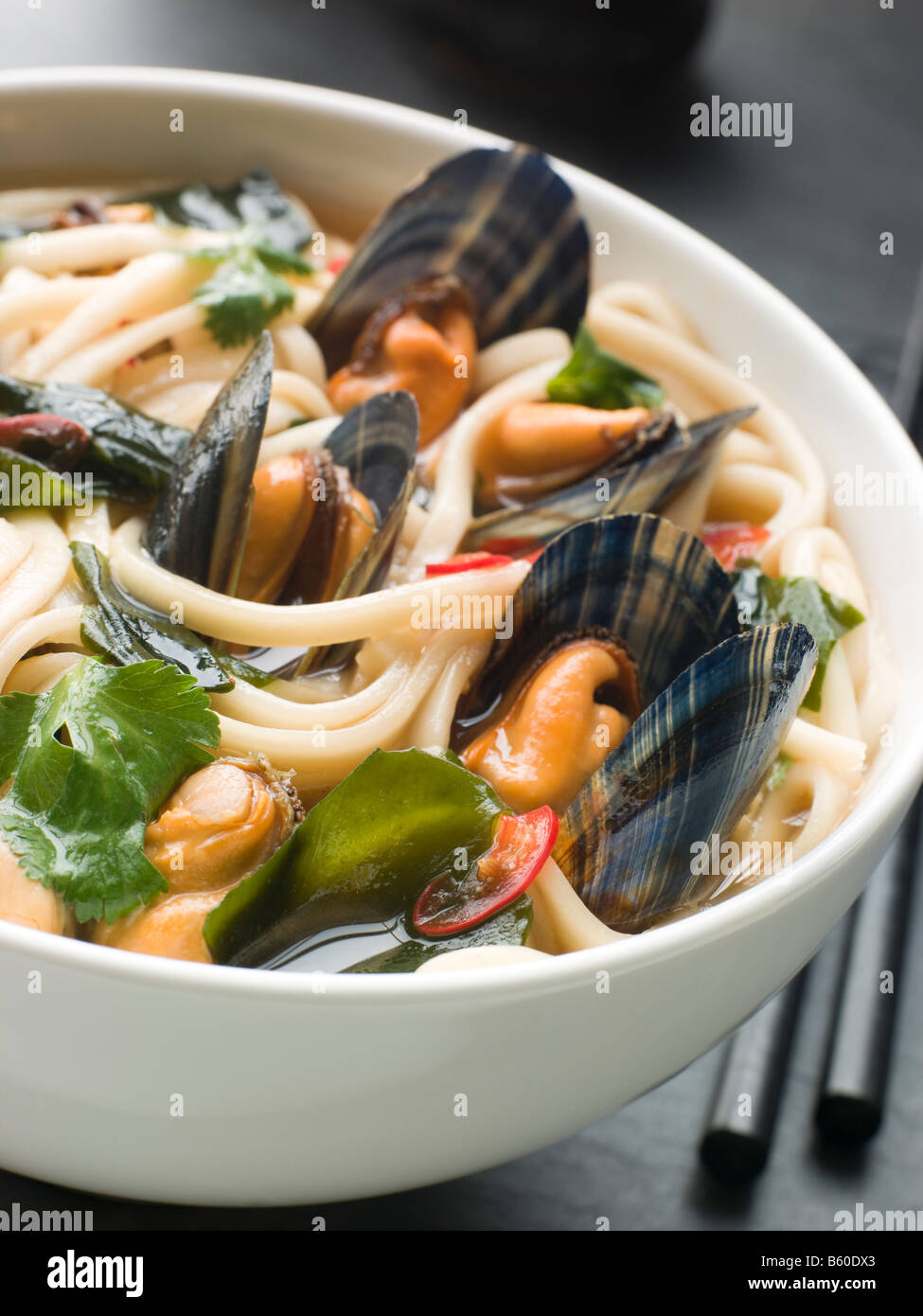 Cozze e Udon tagliatelle Chili in brodo di soia Foto Stock