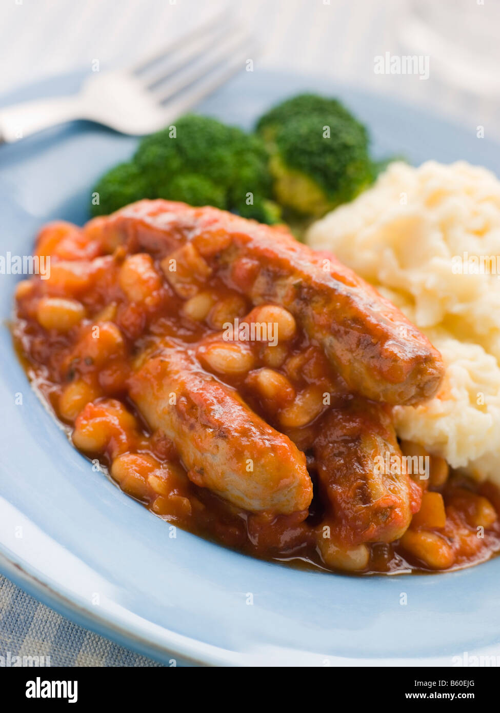 Salsicce e fagioli cotti in casseruola con purea di patate e broccoli Foto Stock