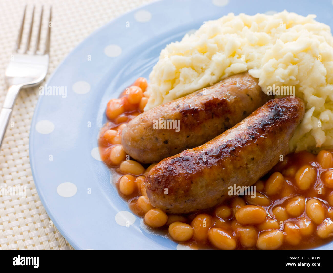 Salsicce e schiacciarle con fagioli al forno Foto Stock