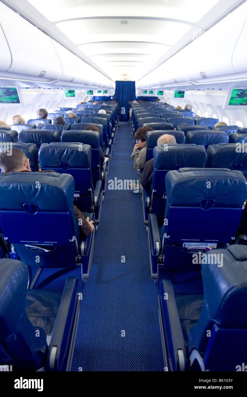 Un ampio angolo di visione del corridoio della cabina passeggeri a bordo di un aereo. Foto Stock