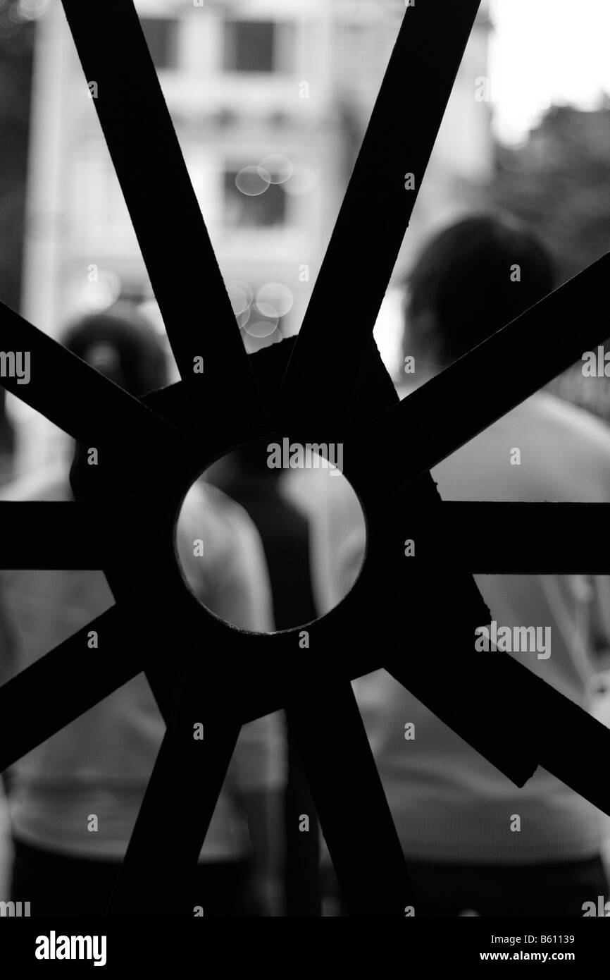 In bianco e nero a contrasto elevato di persone visto attraverso un cancello Abstract Foto Stock