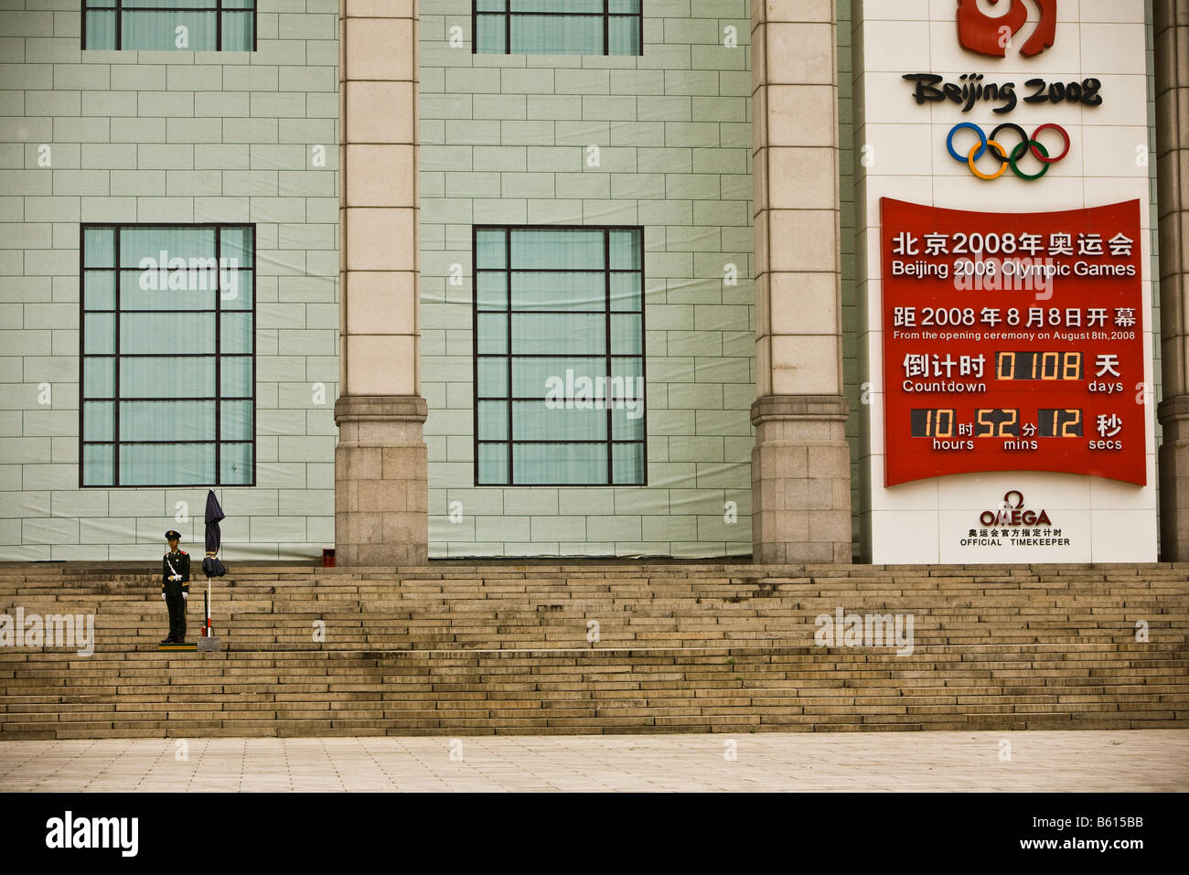 Un soldato sta di guardia di fronte ad un edificio che mostra il conto alla rovescia per il 2008 Olimpiadi di estate a Pechino in Cina Pechino Foto Stock