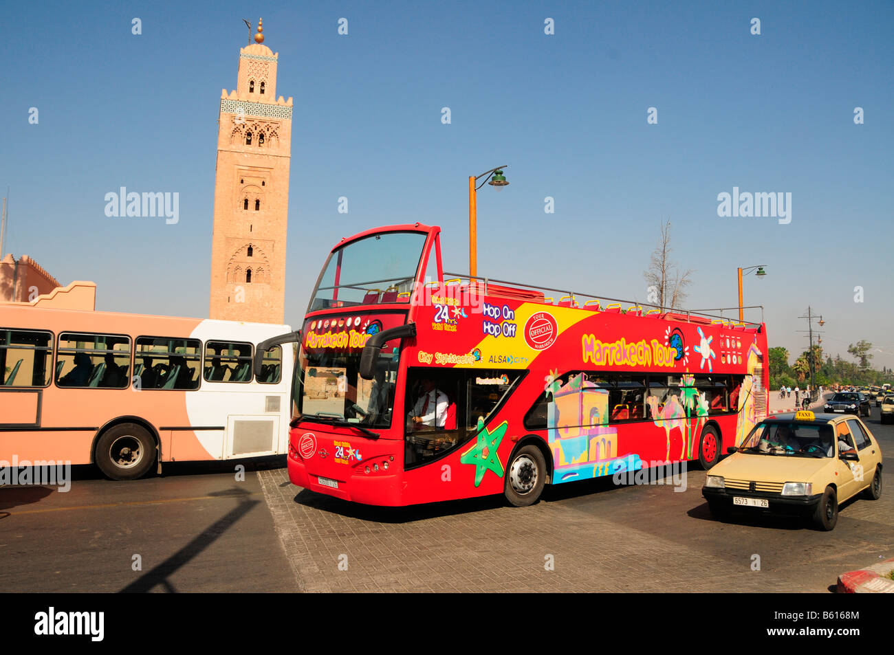 Double-decker open-top autobus turistico di fronte alla Moschea di Koutoubia, Marrakech, Marocco, Africa Foto Stock