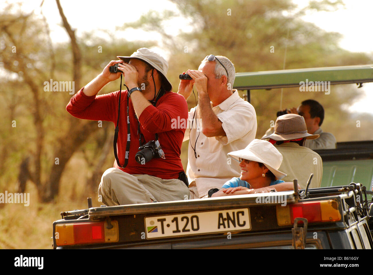 I turisti osservare la fauna selvatica nel parco nazionale del Serengeti, Tanzania Africa Foto Stock