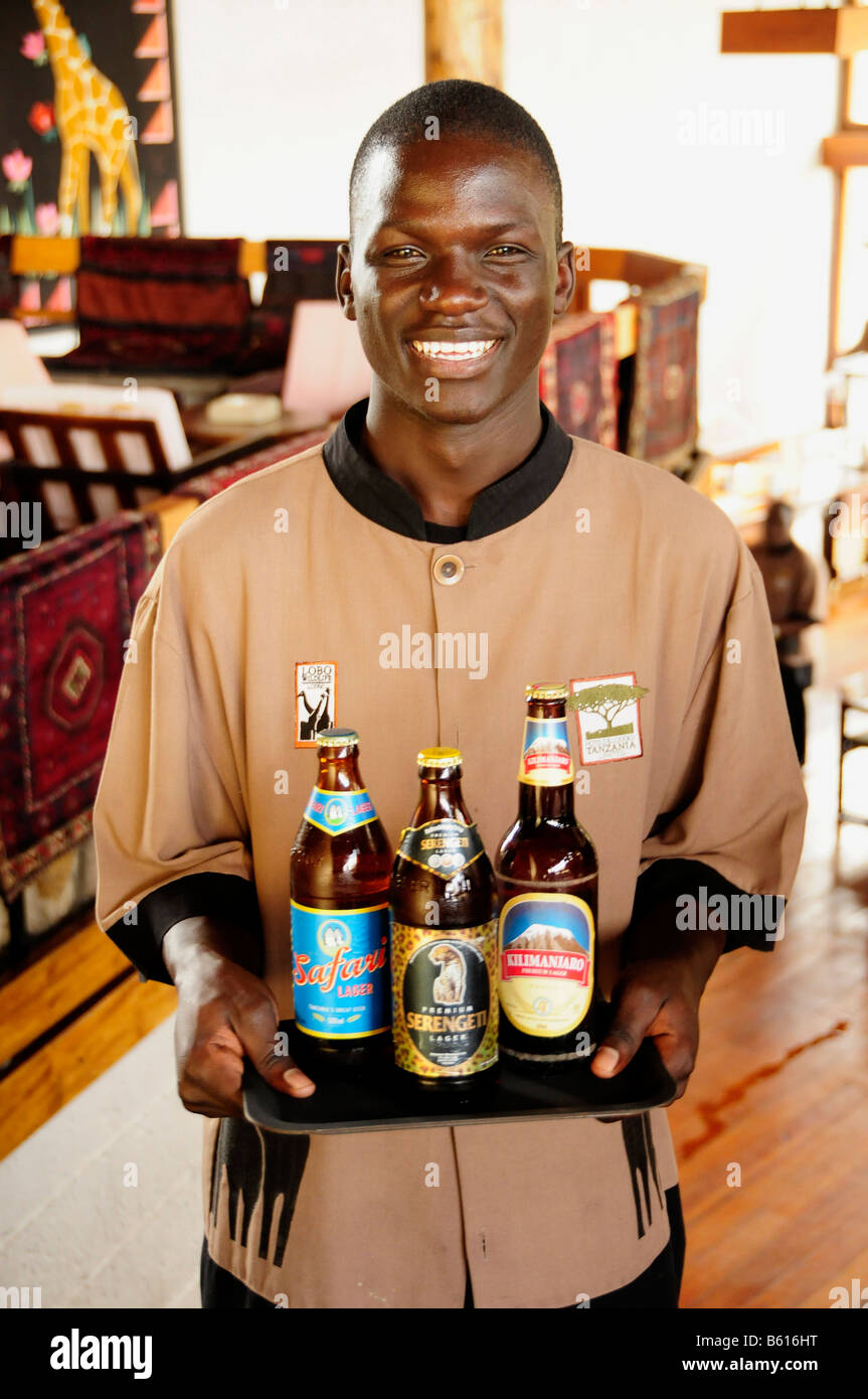 Cameriere che trasportano i tre più popolari birre in Tanzania, Serengeti e Kilimanjaro Safari, Lobo Wildlife Lodge Foto Stock