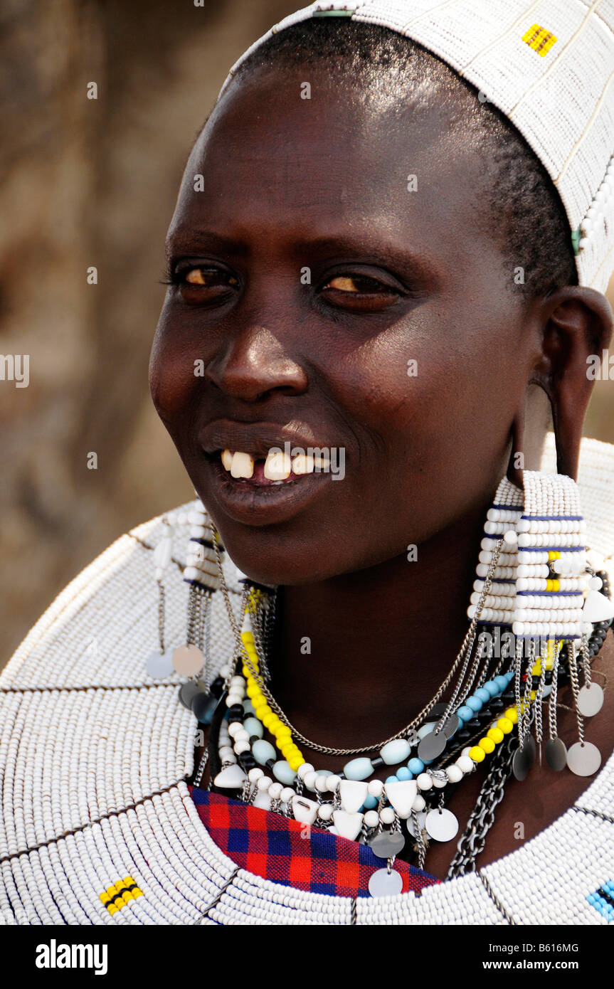 Massai giovane donna con il tipico copricapo in villaggio Kiloki, Serengeti, Tanzania Africa Foto Stock