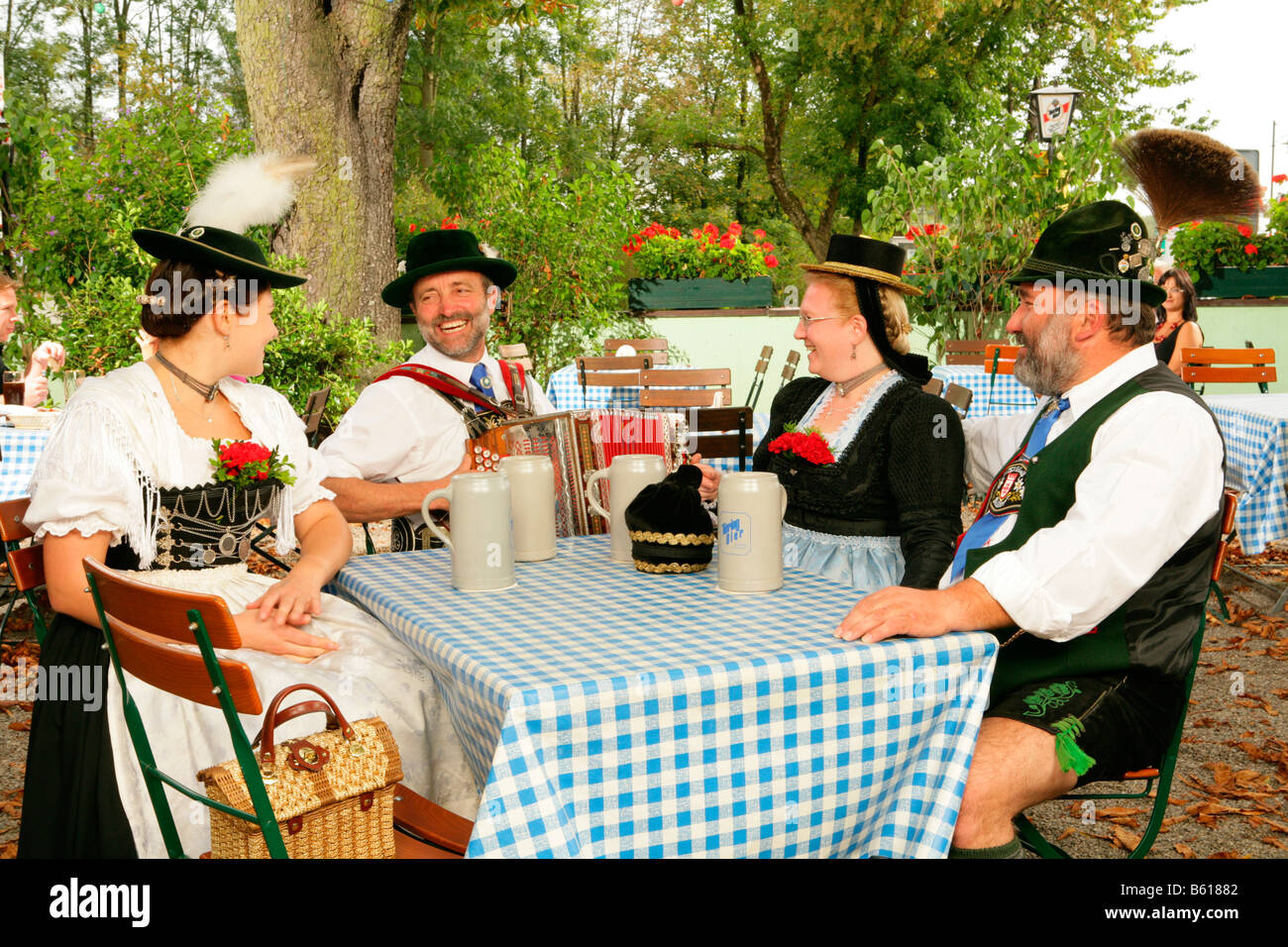 Persone che indossano il costume tradizionale in un giardino della birra, Muehldorf am Inn, Alta Baviera Foto Stock