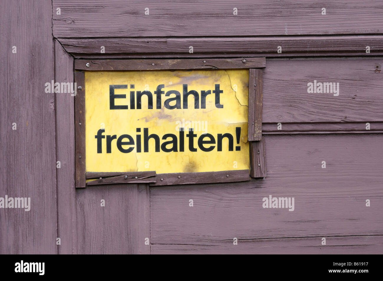 Il vecchio segno giallo su una porta di legno: Einfahrt freihalten!, mantenere l'ingresso chiaro! Foto Stock