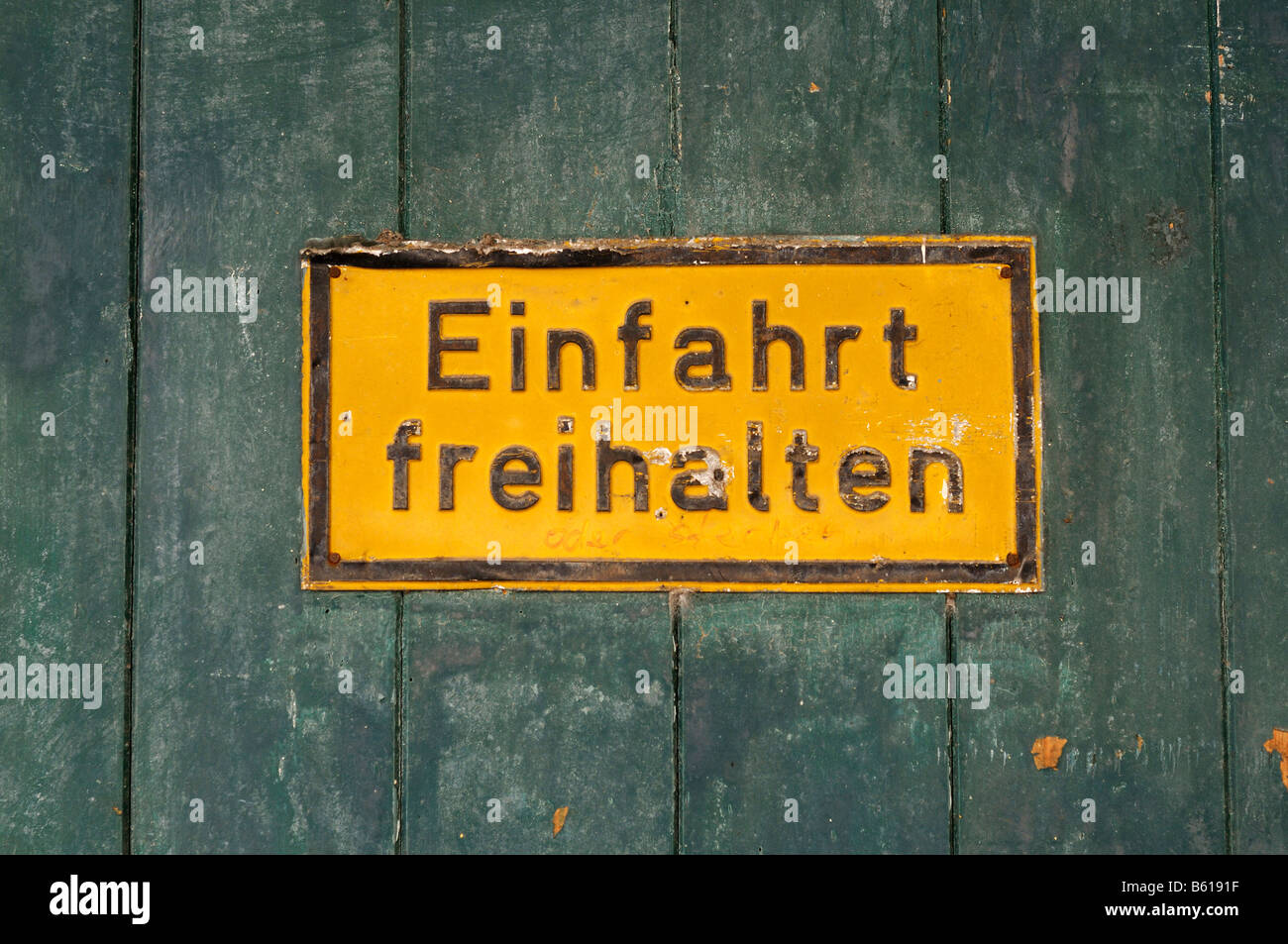 Il vecchio segno giallo su un rustical cancello in legno: Einfahrt freihalten, mantenere l'ingresso chiaro Foto Stock