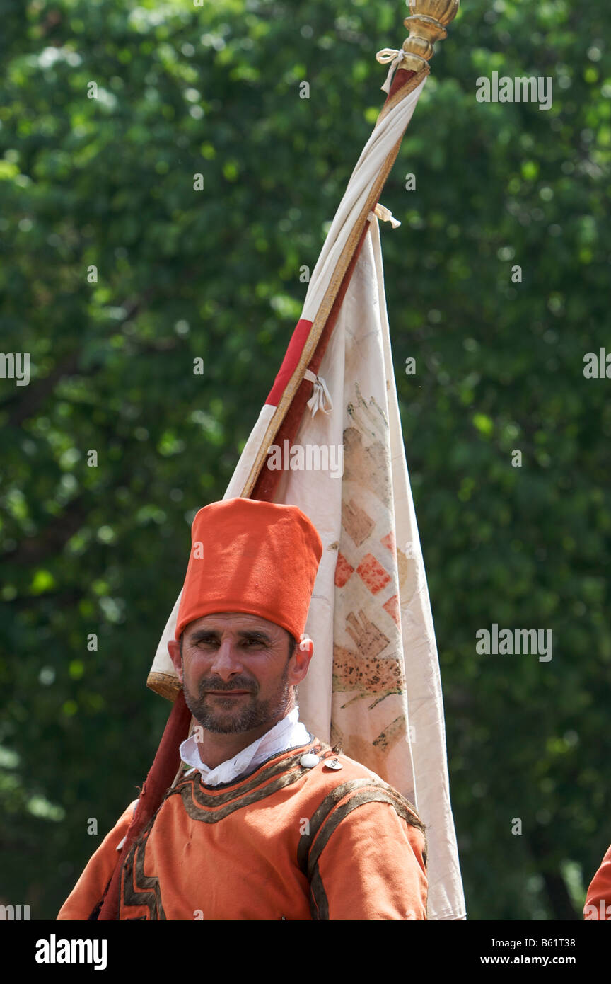 Uomo a cavallo che indossa un costume tradizionale e portante una bandiera alla Cavalcata Sarda parade di Sassari, Sardegna, Italia, Foto Stock