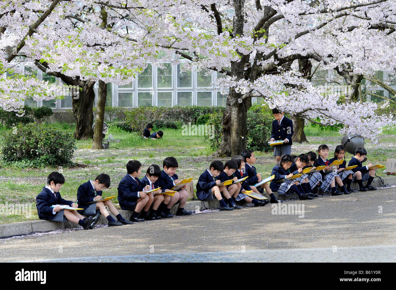 La scuola dei bambini che indossano l'uniforme di un elite scuola primaria durante l'apprendimento attivo nei Giardini Botanici a Kyoto, Giappone, Foto Stock