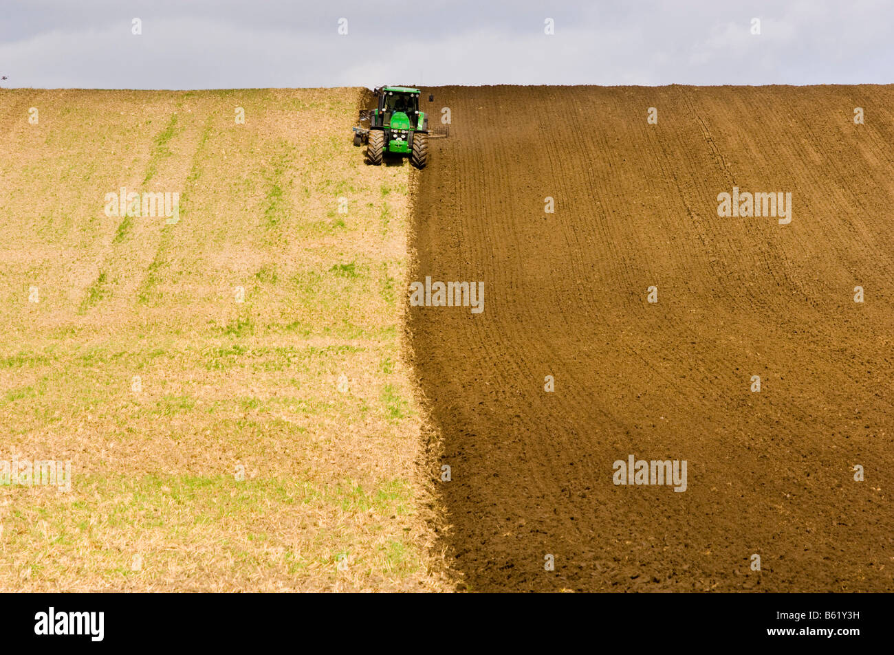 Trattore tirando un aratro, il paesaggio agricolo Foto Stock