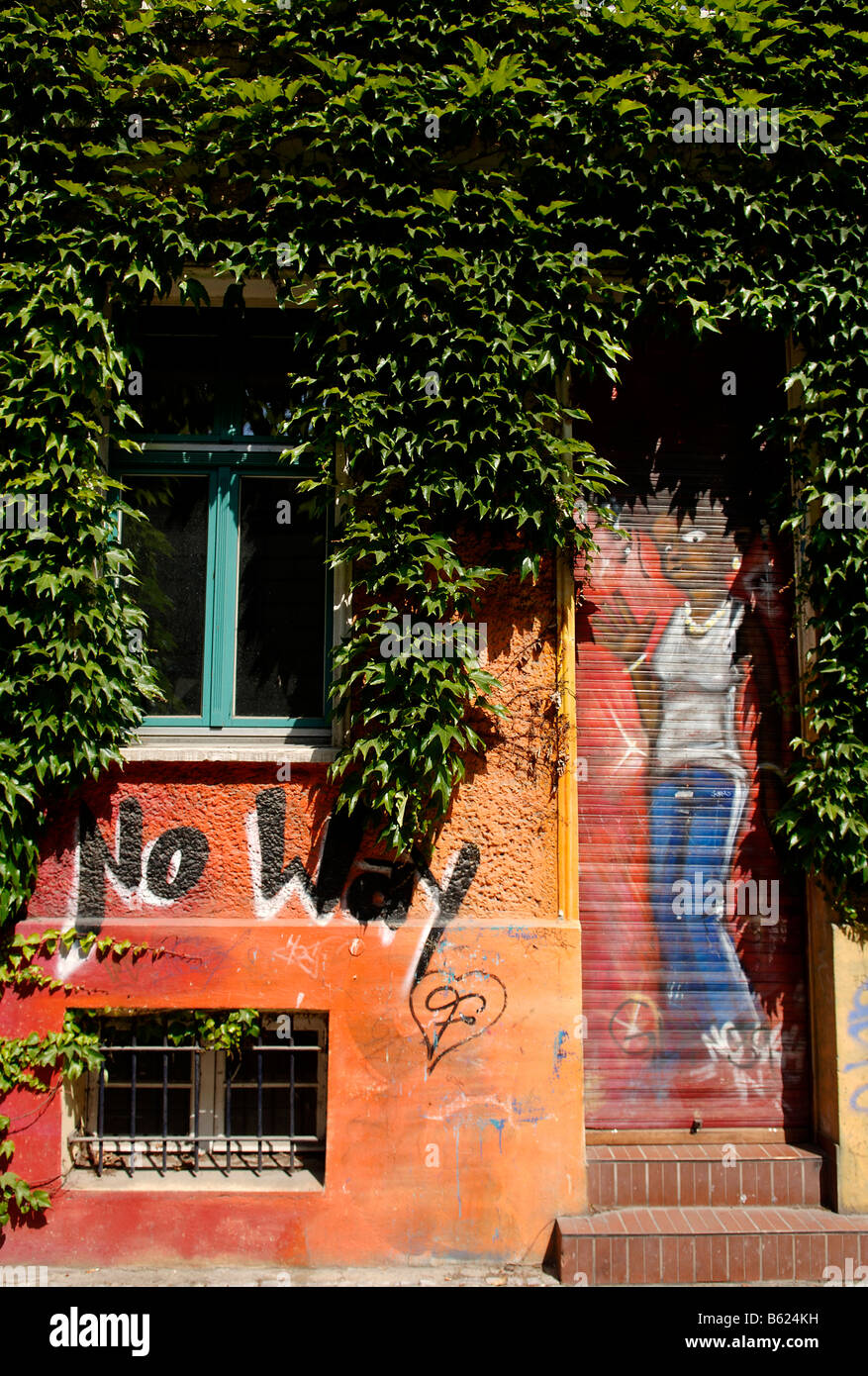 Ingresso Graffitied a una casa ricoperta con viti selvatiche, Berlino, Germania, Europa Foto Stock