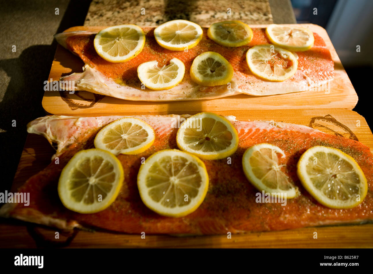 Due metà di un salmone sockeye sono condite e preparata per la griglia su imbevuto di tavole di cedro Foto Stock