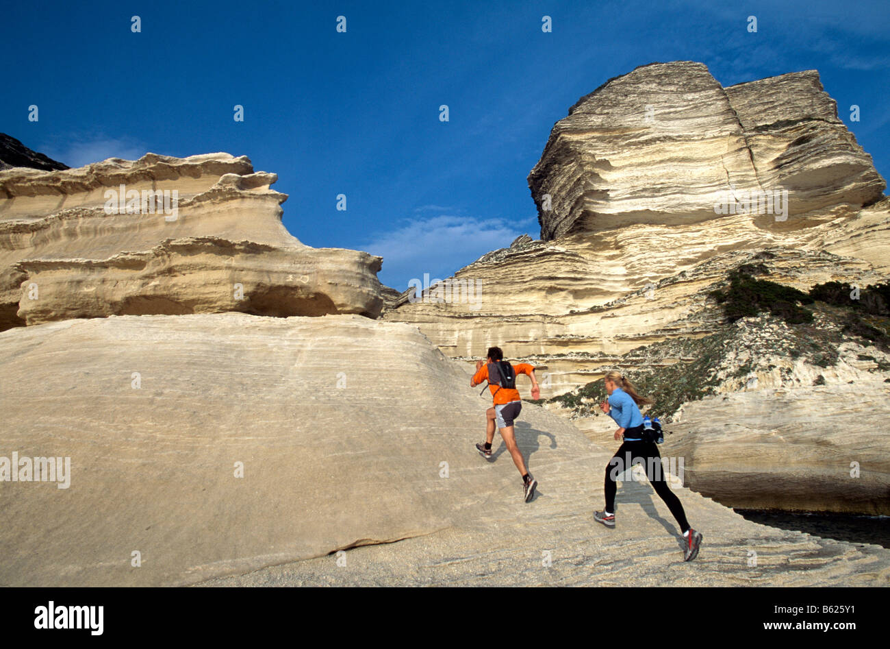 Un uomo e una donna che partecipano in esecuzione, Crossrunning, ripida costa, Santa Manza, Bonifacio, Corsica, Francia, Europa Foto Stock