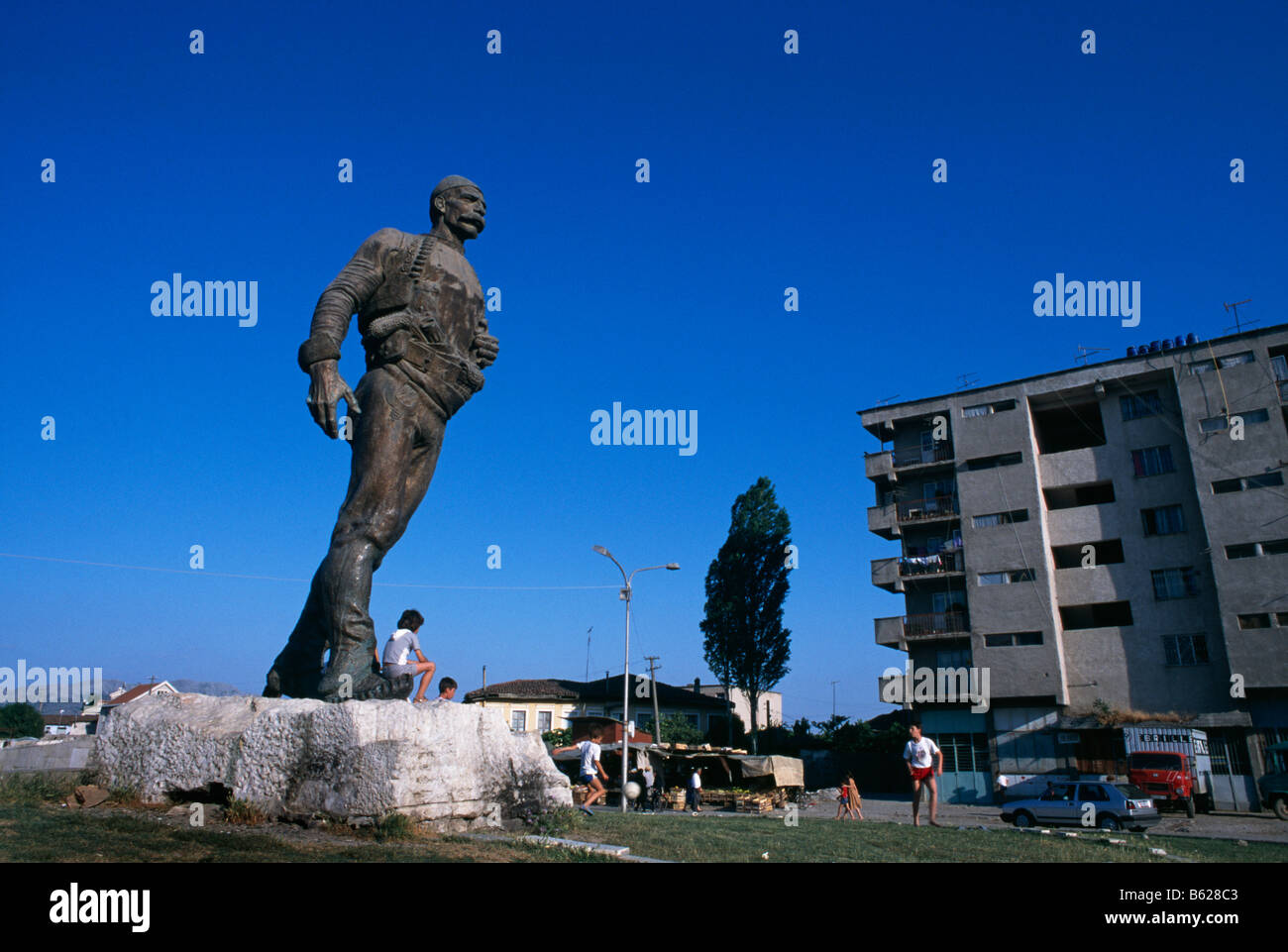 Scena di strada con la statua di Isa Bolitini in Shkodra, Albania, 1994 Foto Stock