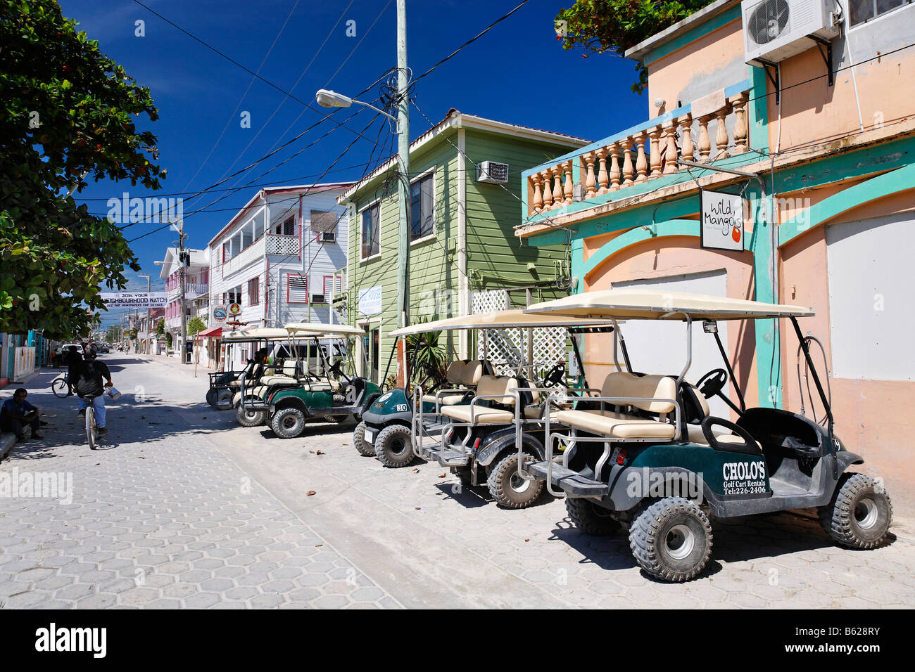 Golf carts parcheggiato sulla strada principale, la più diffusa forma di trasporto in San Pedro, Ambergris Cay Isola, Belize, Central Am Foto Stock