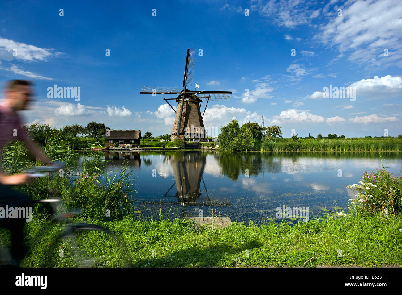 Paesi Bassi Zuid Holland Kinderdijk mulini a vento Unesco World Heritage Site uomo in bicicletta Foto Stock