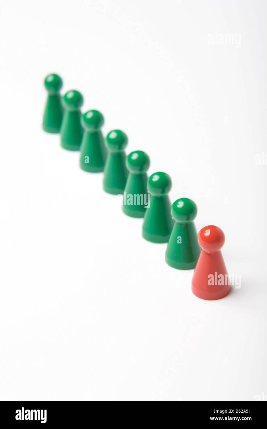 Verde di pezzi di gioco in piedi in fila dietro a un singolo red gaming pezzo, simbolico della leadership Foto Stock