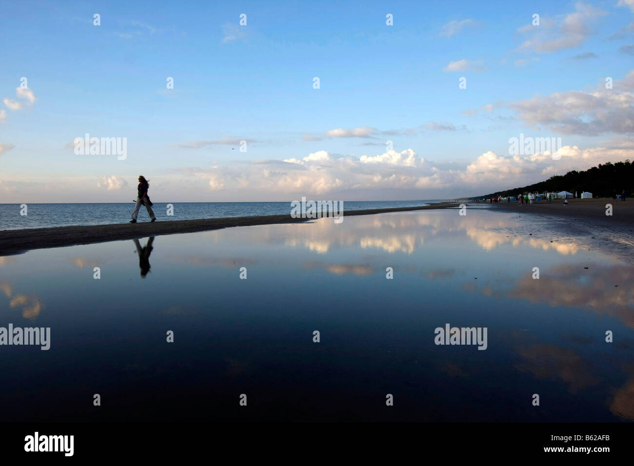 Il camminatore solitario riflessa nell'acqua poco profonda presso la spiaggia di Jurmala, Lettonia, la regione del Mar Baltico, Europa Foto Stock