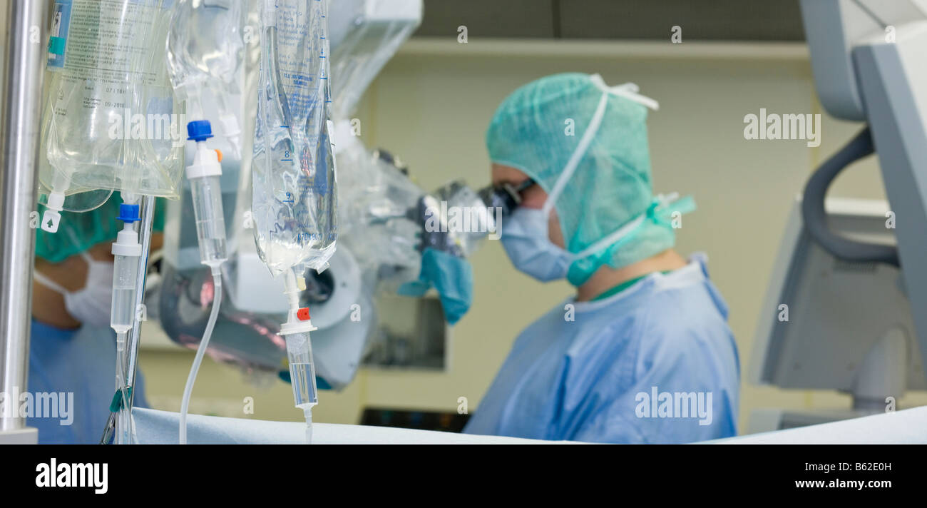 Neurochirurgo usando microscopio durante la procedura chirurgica per rimuovere un benigne tumore al cervello, Reykjavik, Islanda Foto Stock