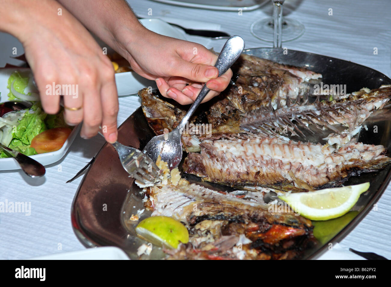Cameriera di preparazione del pesce a servire a tavola ristorante borgo di Maia isola Sao Miguel Azzorre Foto Stock