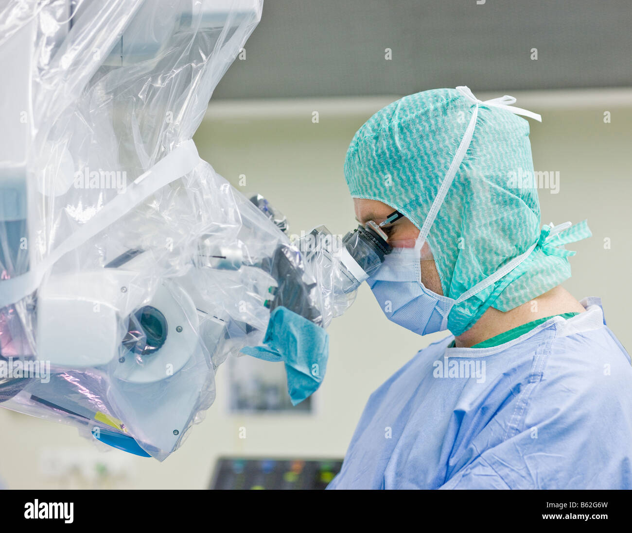Neurochirurgo utilizzando hi-tech microscopio durante la procedura chirurgica per rimuovere un benigne tumore al cervello, Reykjavik, Islanda Foto Stock