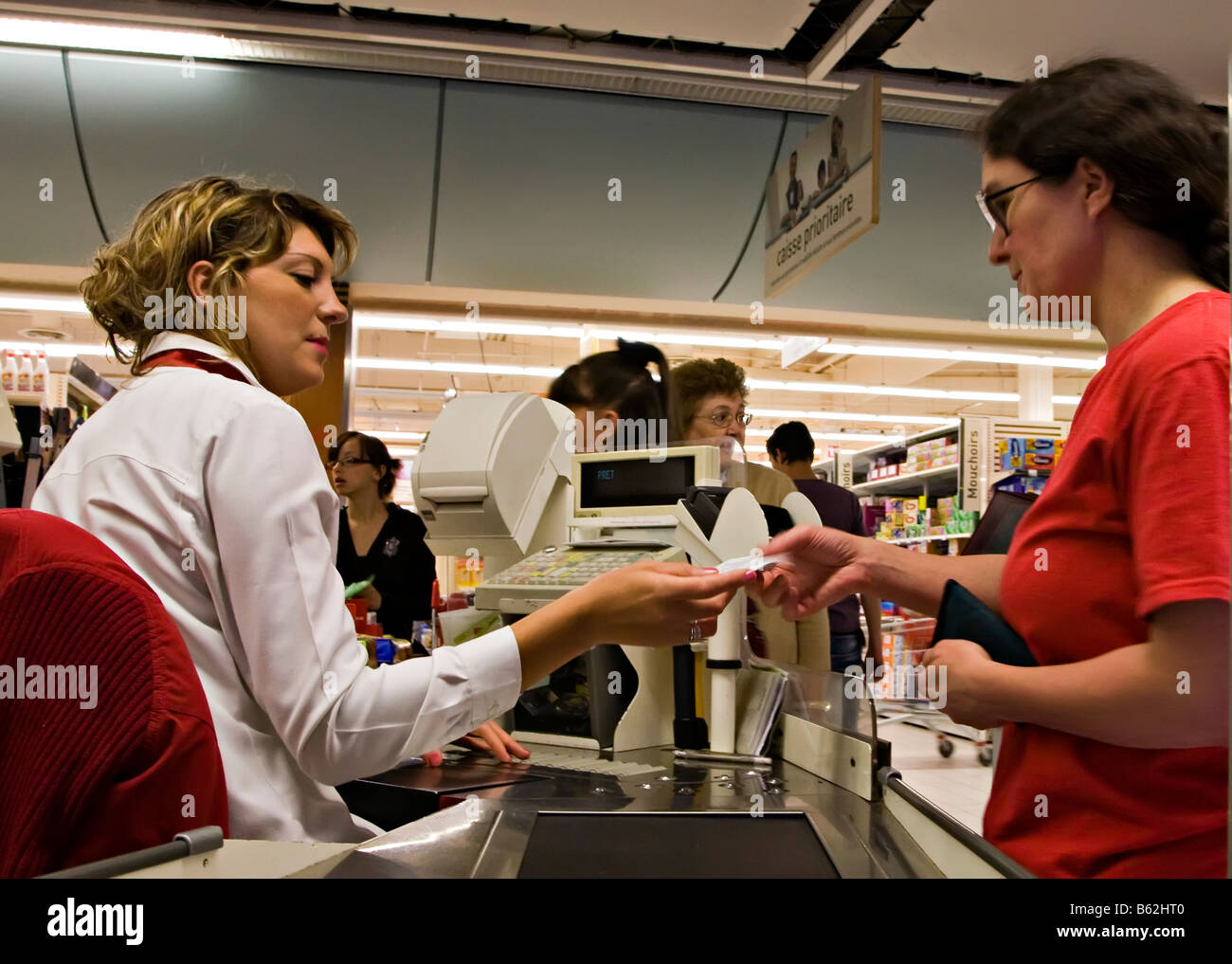 Donna prendendo ricevuta dalla donna fino al supermercato Francia Foto Stock