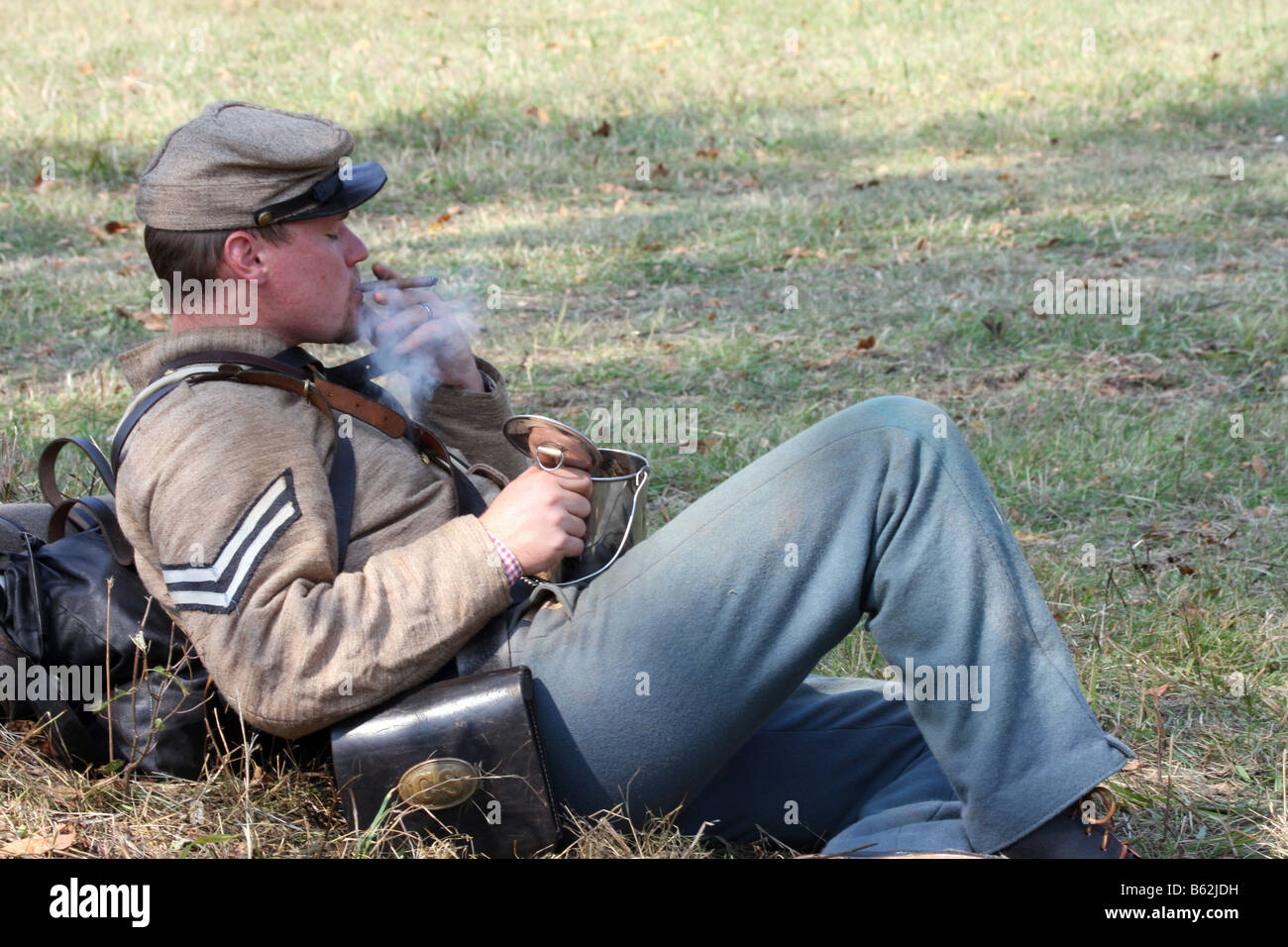Un confederato guerra civile militare in pausa mangiando e avente un sigaro durante una guerra civile Rievocazione Storica presso la vecchia casa di Wade Foto Stock