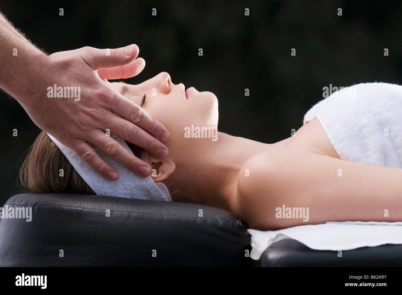 Profilo laterale di una giovane donna getting massaggio da una terapista di massaggio Foto Stock