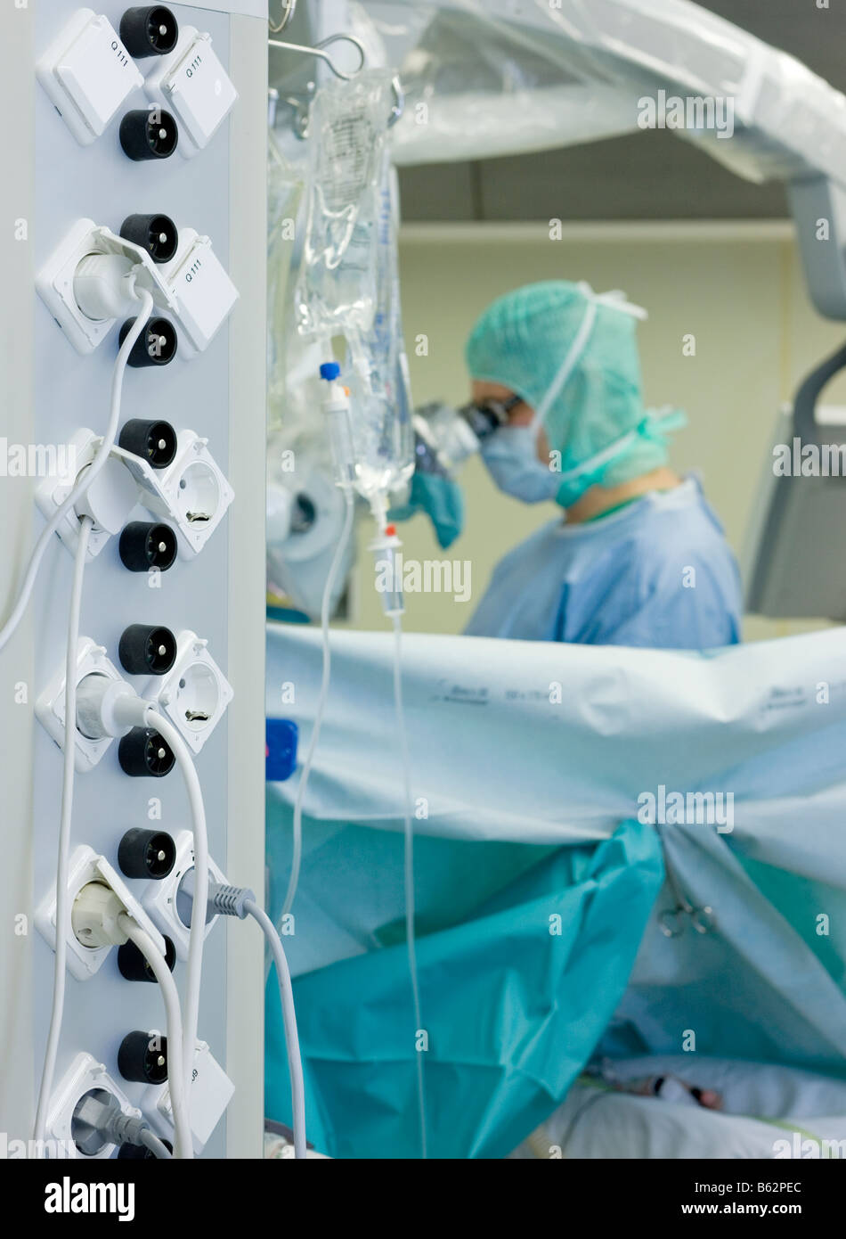 Neurochirurgo usando microscopio durante la procedura chirurgica per rimuovere un benigne tumore al cervello, Reykjavik, Islanda Foto Stock