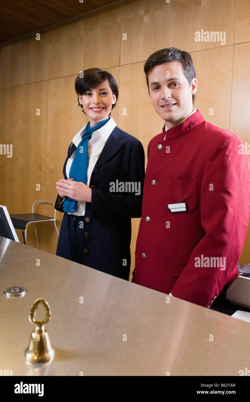 Ritratto di una donna addetta alla reception e un cameriere presso la reception dell' hotel Foto Stock
