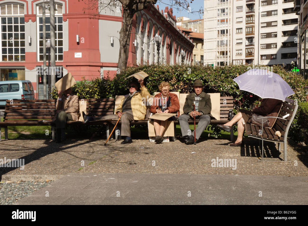 Un gruppo di pensionati seduti sui banchi del parco in Gijon Spagna Foto Stock