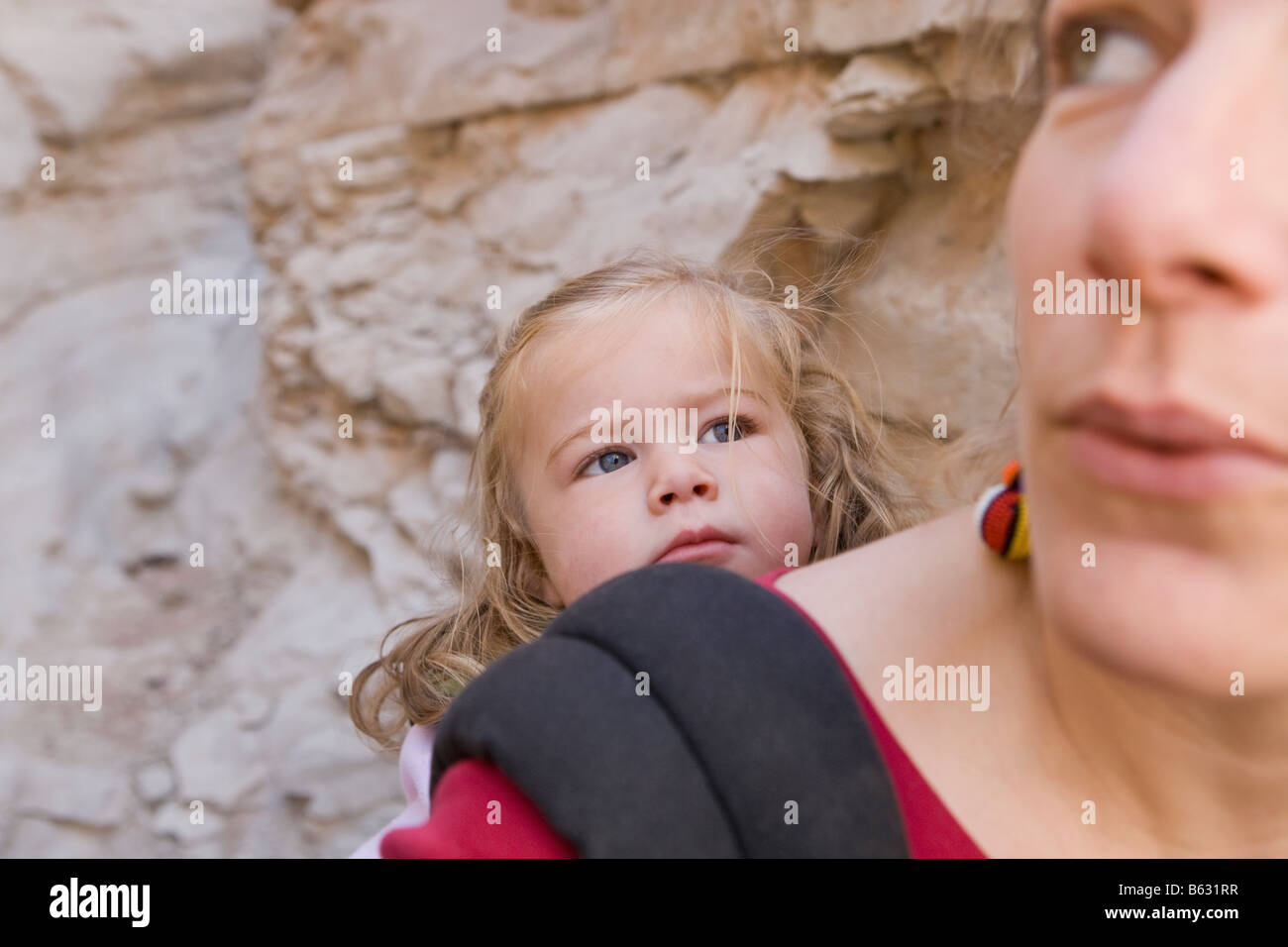 Close-up di una metà donna adulta che porta la figlia in un baby carrier Foto Stock