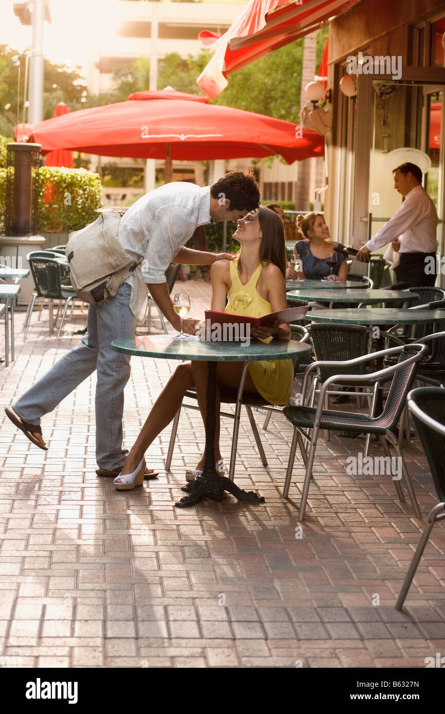Coppia giovane kissing presso un cafè sul marciapiede Foto Stock