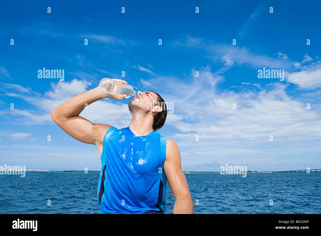 Giovane uomo di bere acqua da una bottiglia di acqua Foto Stock