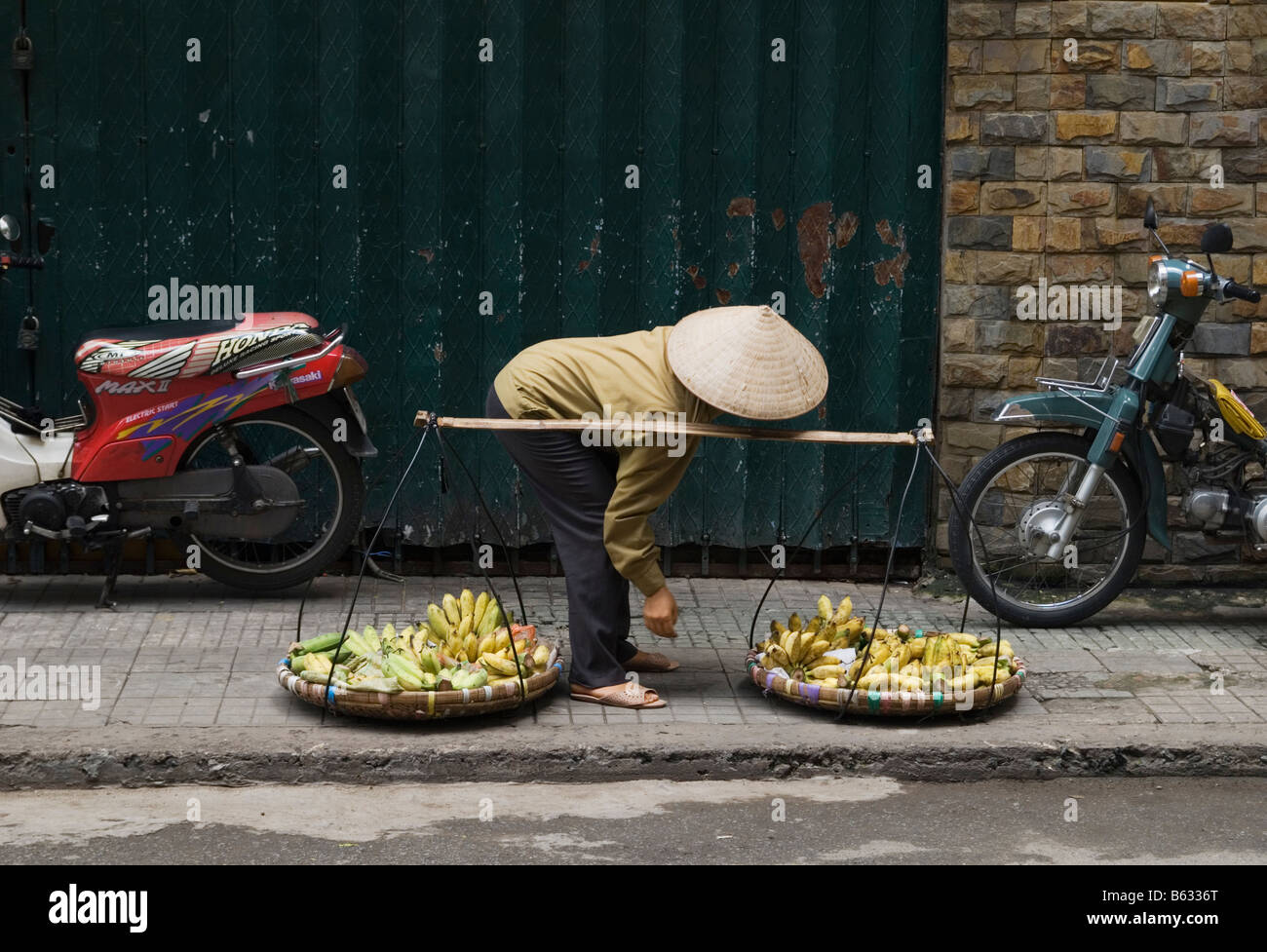 Vietnamese street trader indossando una foglia conica hat, Ho Chi Minh City, Vietnam Foto Stock