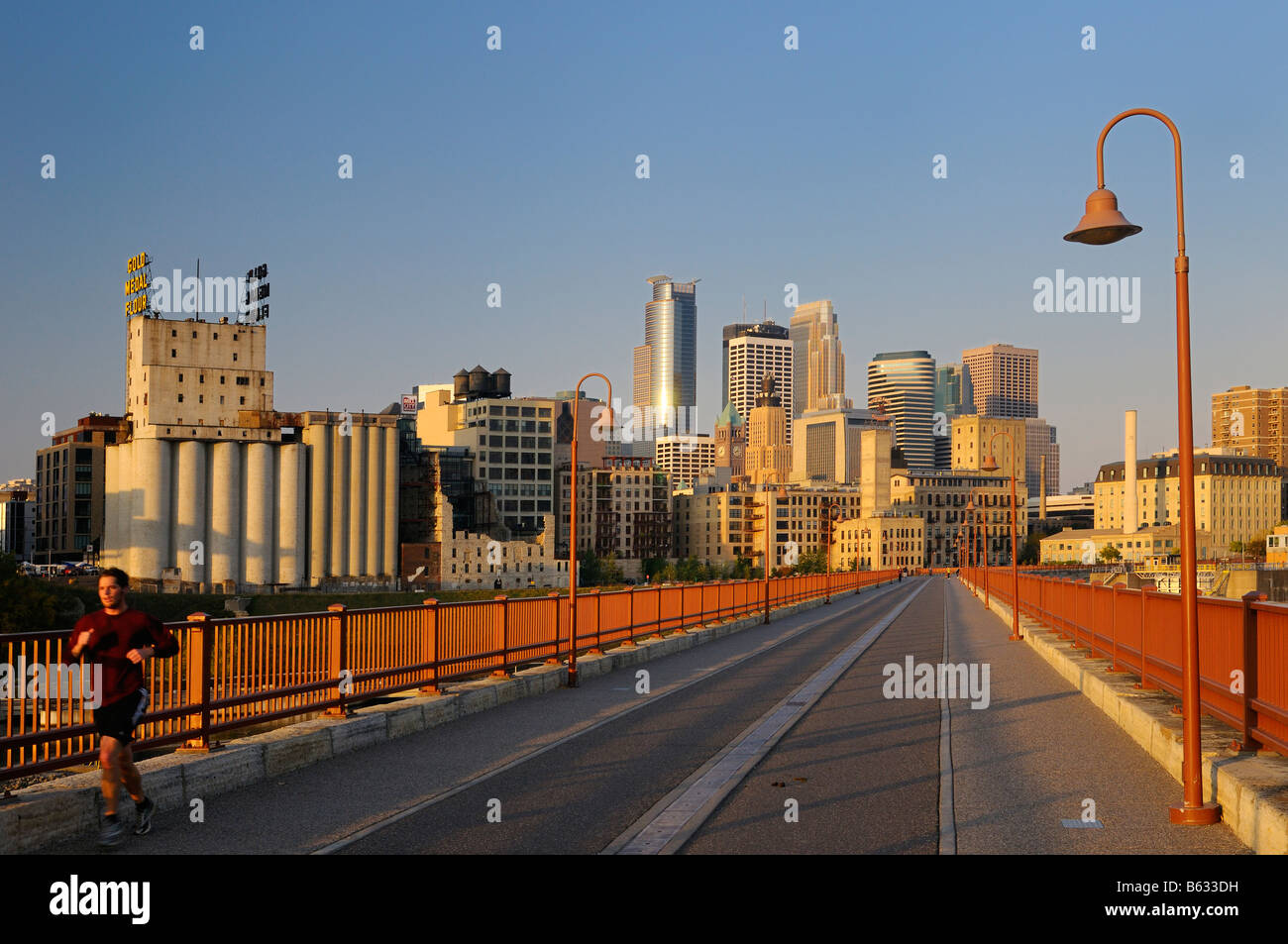 La mattina presto e il pareggiatore Minneapolis highrise tower skyline dalla pietra il ponte di arco di sunrise Foto Stock