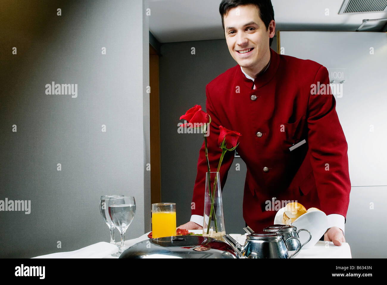 Ritratto di un cameriere spingendo il carrello della colazione Foto Stock