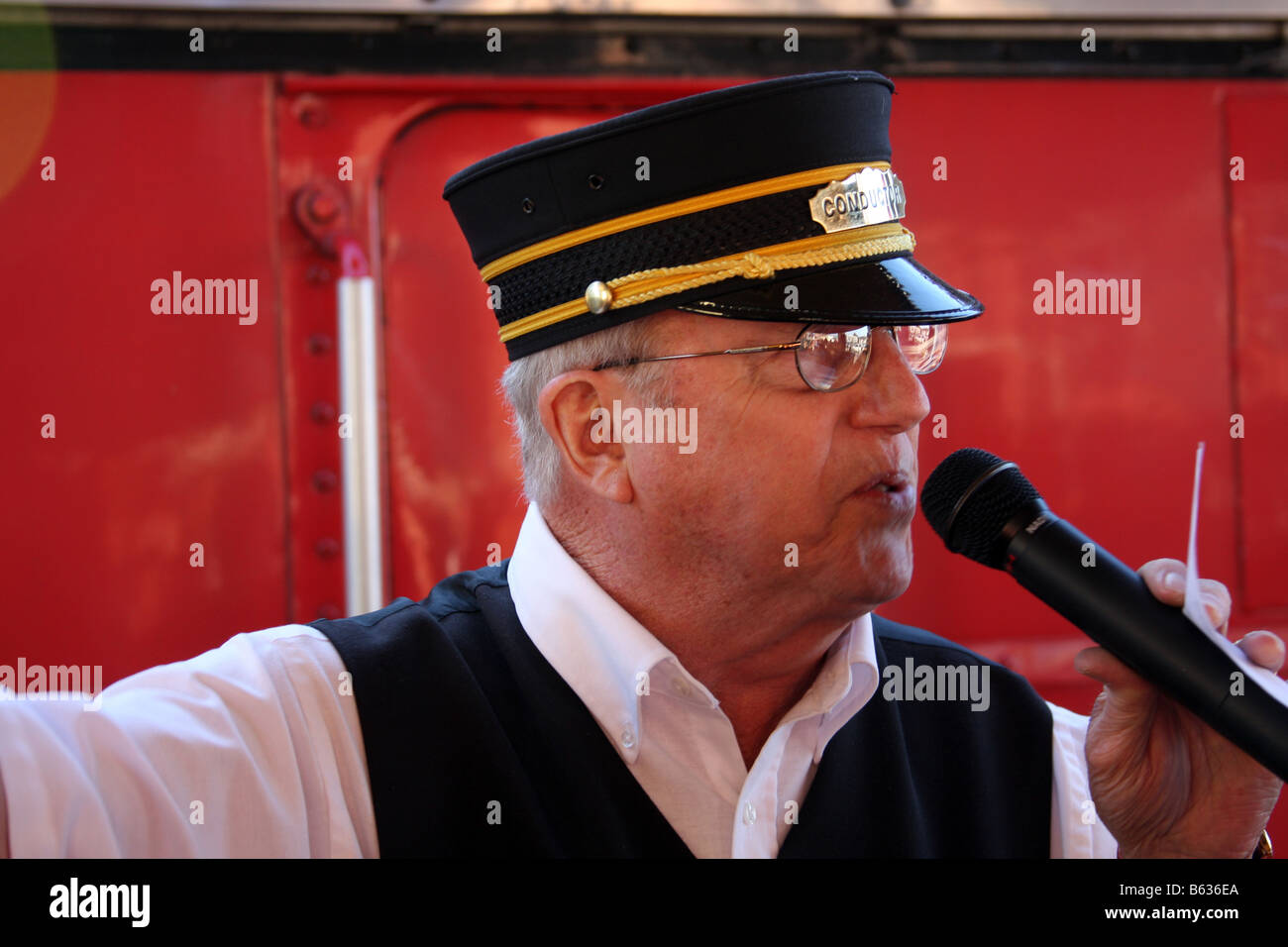 Il conduttore di parlare con i passeggeri con un microfono prima di salire a bordo del Branson Scenic Railway treno diesel Foto Stock