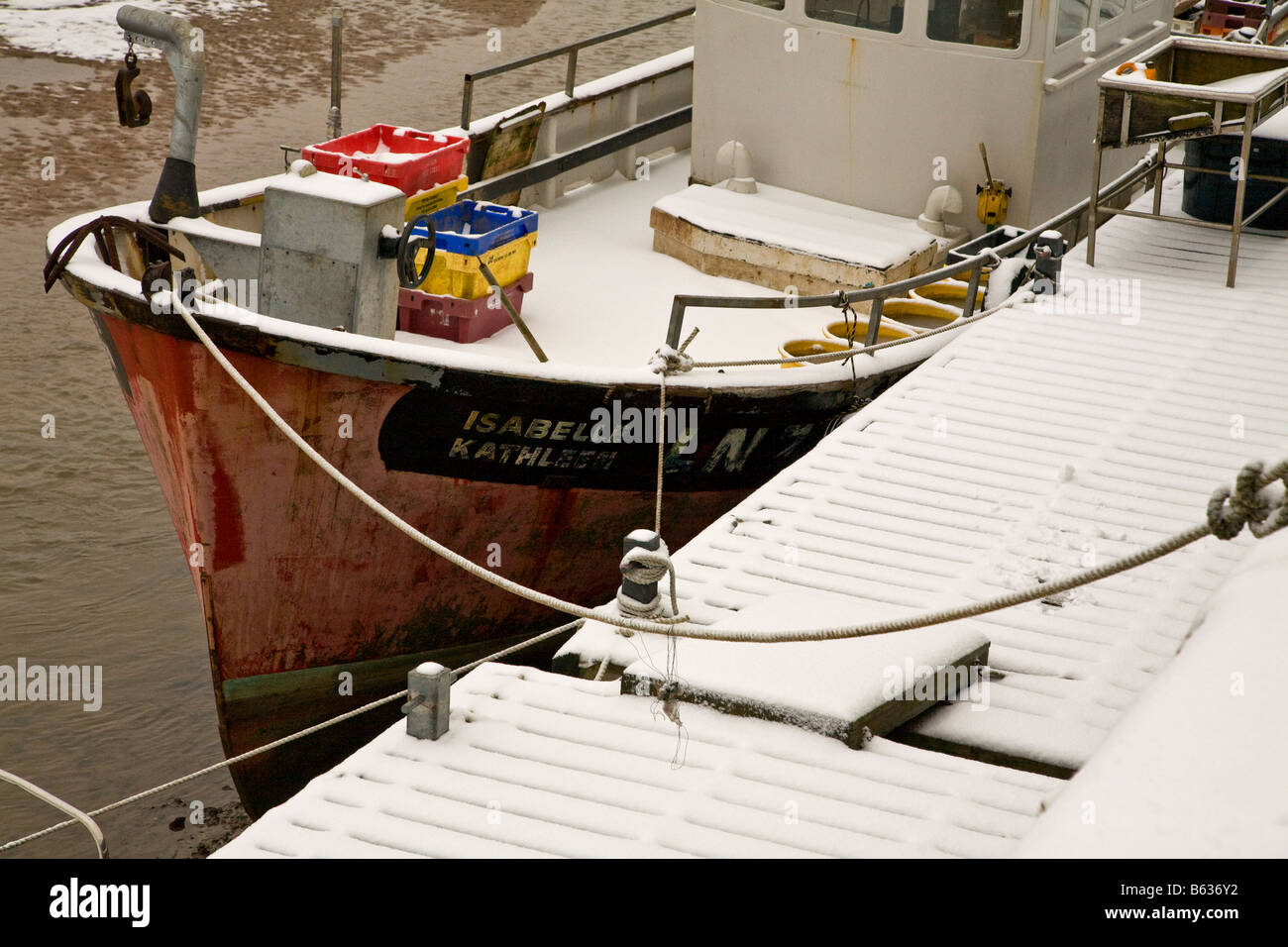 La pesca in barca ormeggiata lungo la banchina a neve Foto Stock