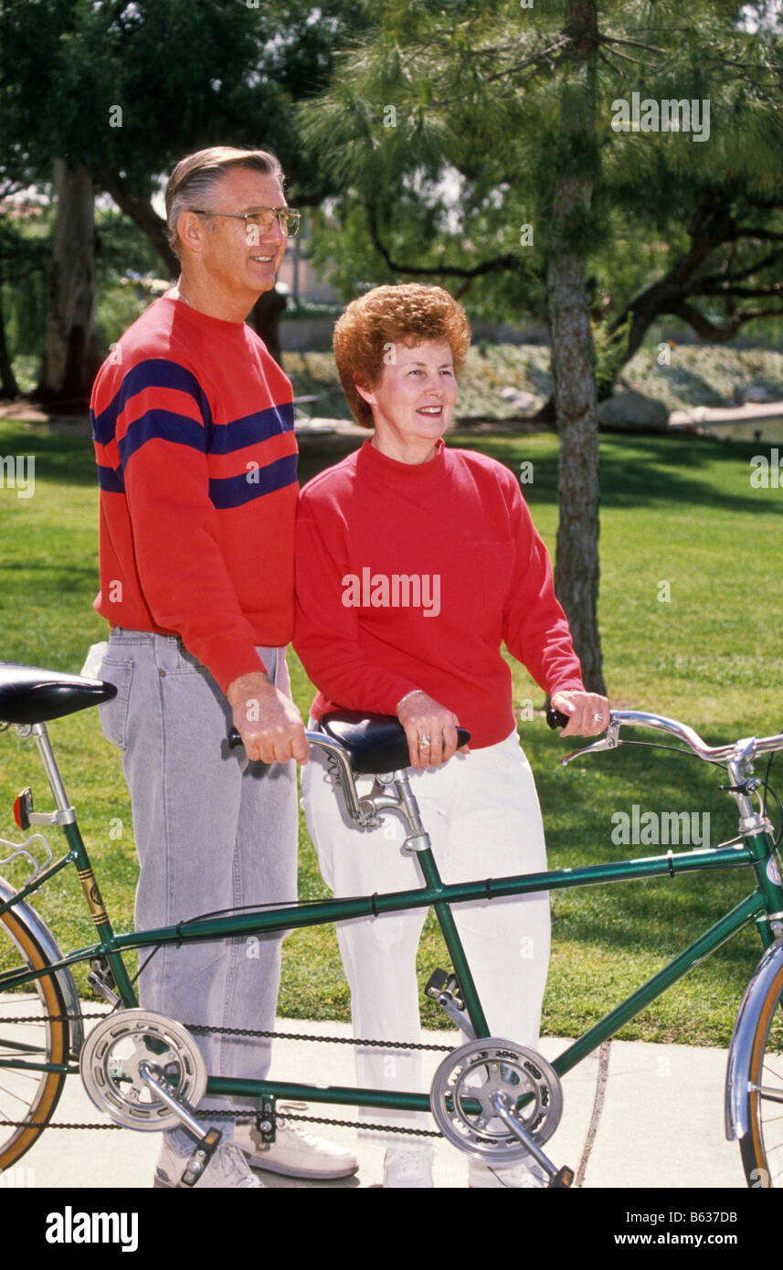 Coppia senior corsa biciclette tandem nel parco. Foto Stock