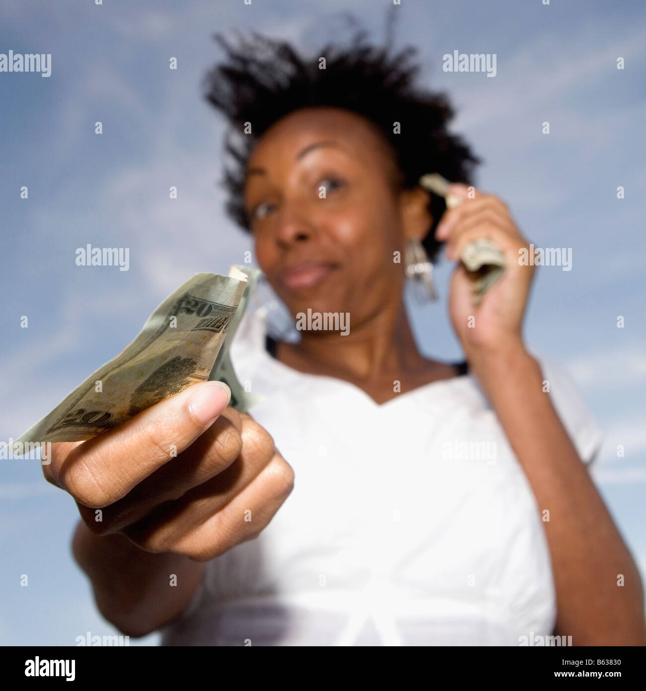 Close-up di una giovane donna che mostra una ventina di dollari Foto Stock