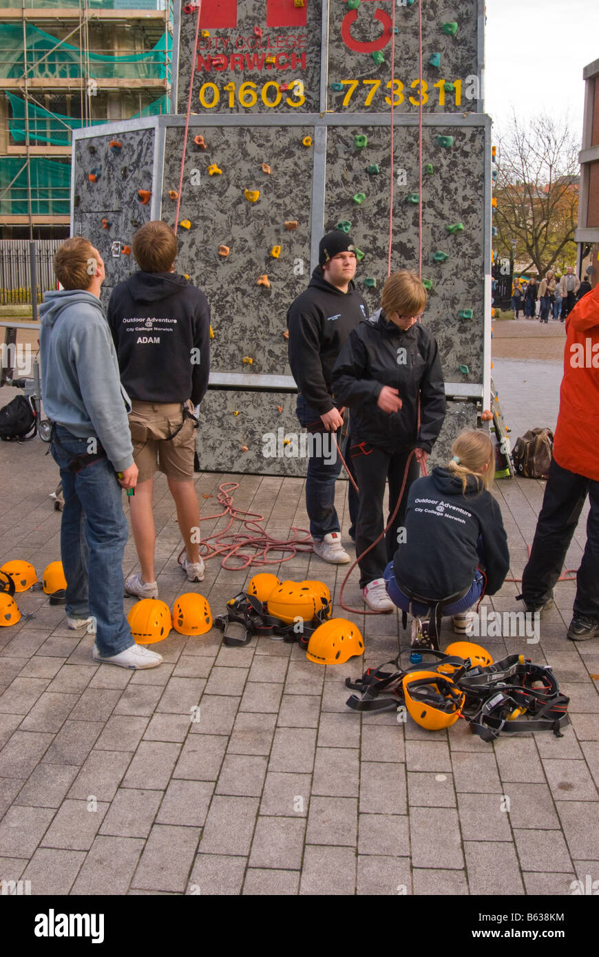 Le persone che stanno imparando l'arrampicata su aperatus per arrampicata utilizzando cavi di sicurezza e caschi nel Regno Unito Foto Stock