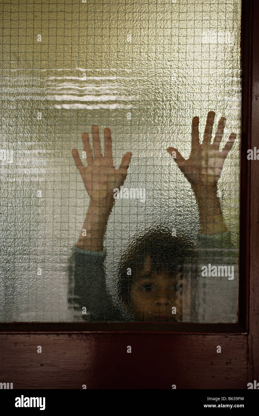 6 anno vecchio ragazzo dietro il vetro Foto Stock